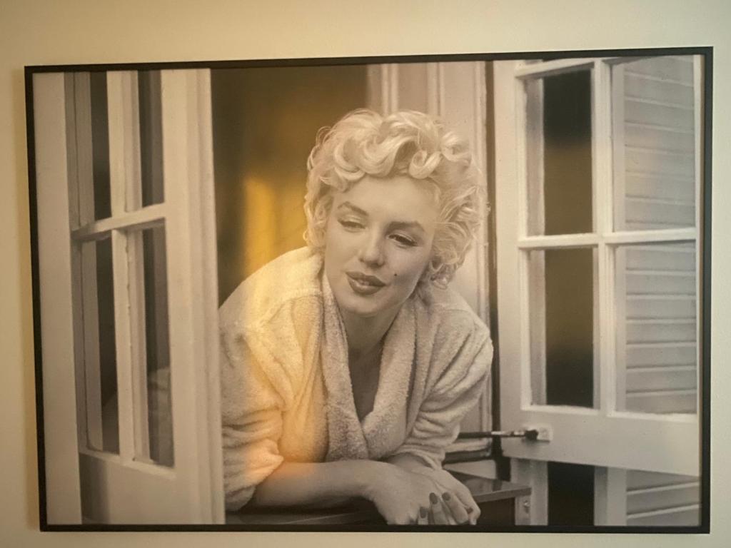 une peinture d'une femme qui regarde par une fenêtre dans l'établissement Très Bel Appartement Palais Festivals Plage Croisette Suquet, à Cannes