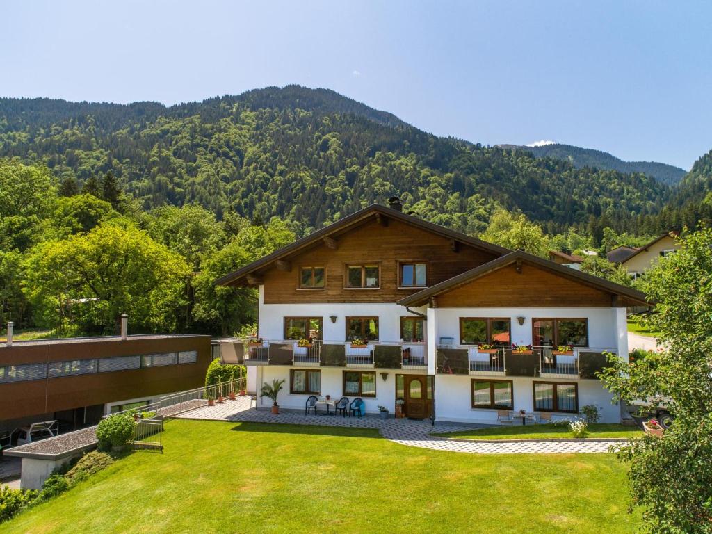 a house with a large yard in front of a mountain at Apartment Marina in Vandans