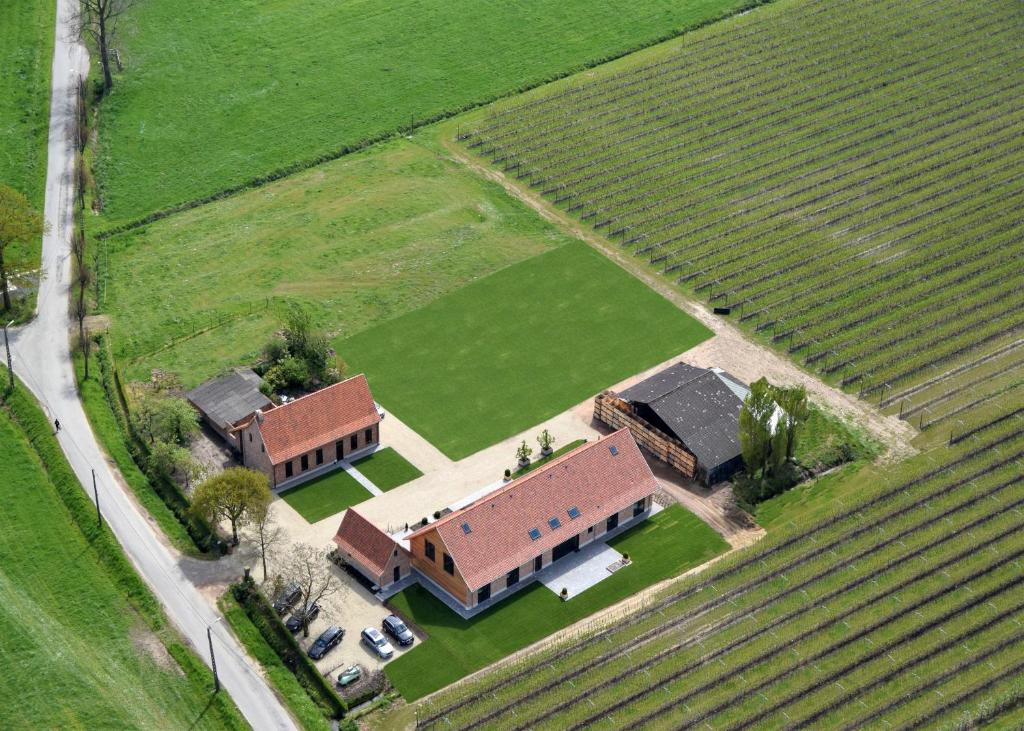 une vue aérienne sur une maison dans un champ dans l'établissement Vakantiehoeve Berckelaer, à Saint-Gilles-Waes