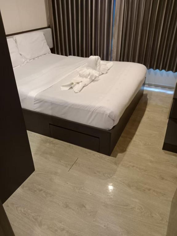 a bed with a white towel on top of it at 芭提雅市中心The Base 高端公寓酒店 in Pattaya