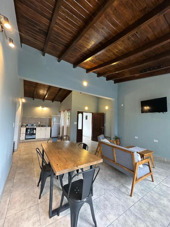 a dining room with a wooden table and a couch at EL PEDREGAL cabaña rural de 1 domitorio hasta 4 personas in Cafayate