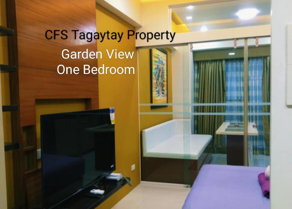 a living room with a tv and a bed at Tagaytay Cozy 1BR Wind Residences in Kaybagal