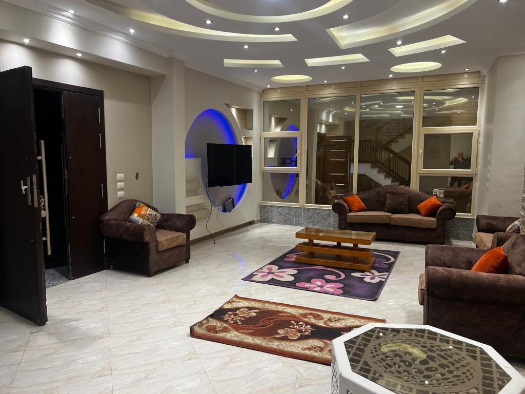 un salon avec des canapés et une télévision à écran plat dans l'établissement فيلا السعادة, au Caire