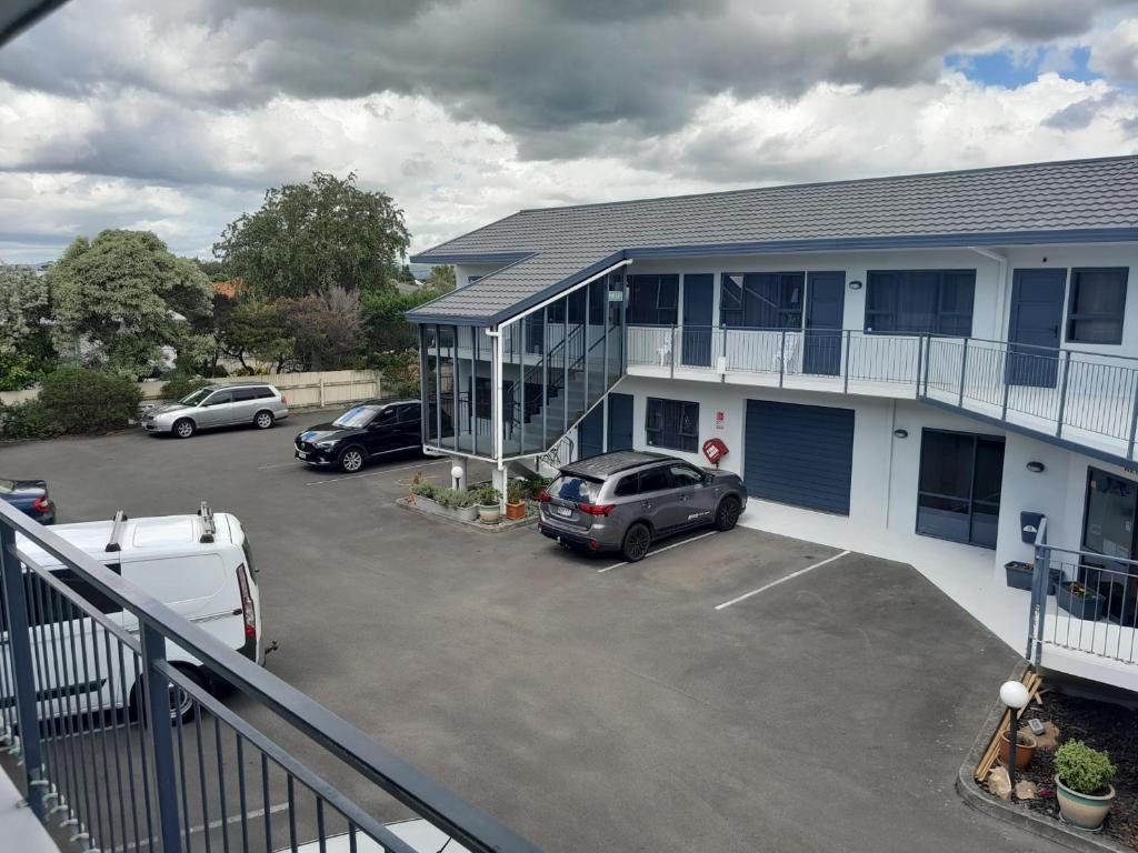 un'auto parcheggiata in un parcheggio di fronte a un edificio di A'Abode Motor Lodge a Palmerston North