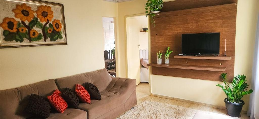 a living room with a couch and a flat screen tv at Casa Chico Rei in Ouro Preto