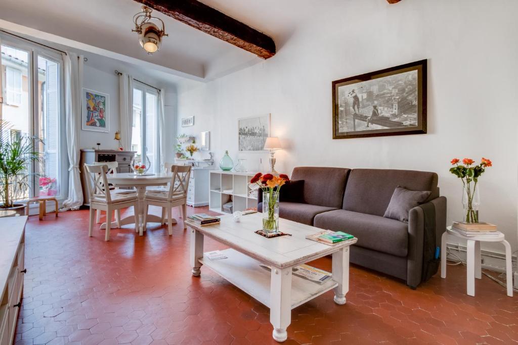 a living room with a couch and a table at Le Van Loo in Aix-en-Provence