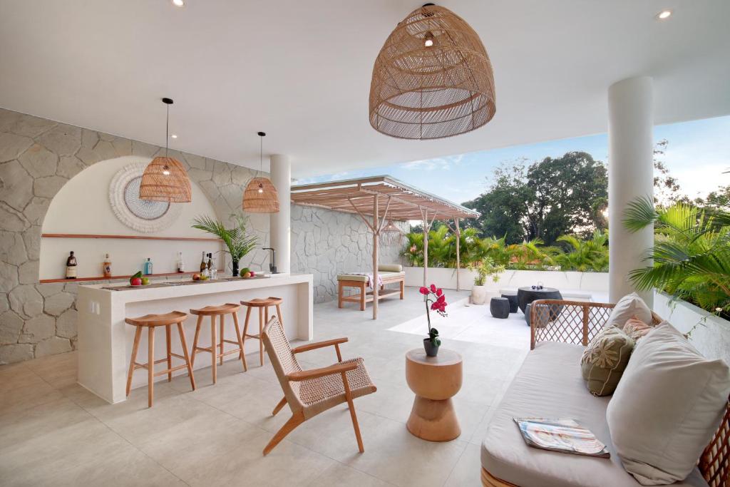 a kitchen and living room with a bar and chairs at Villa Sugi Umalas in Canggu