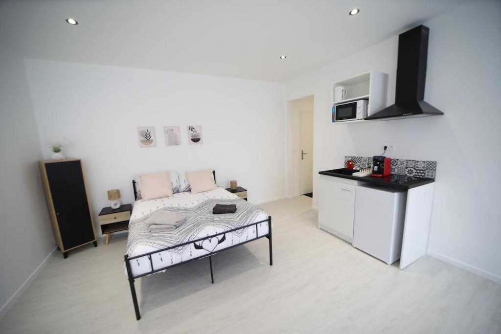 Cette chambre blanche dispose d'un lit et d'une cuisine. dans l'établissement Paul Bert4-ancienne version, à Cambrai