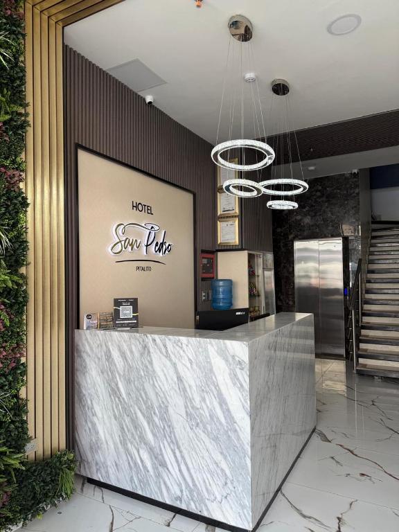 Un vestíbulo con mostrador de recepción en un edificio. en HOTEL SAN PEDRO PITALITO, en Pitalito