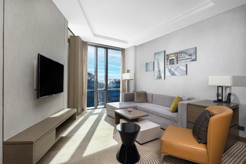 a living room with a couch and a tv at Hyatt House Shanghai Hongqiao CBD in Shanghai