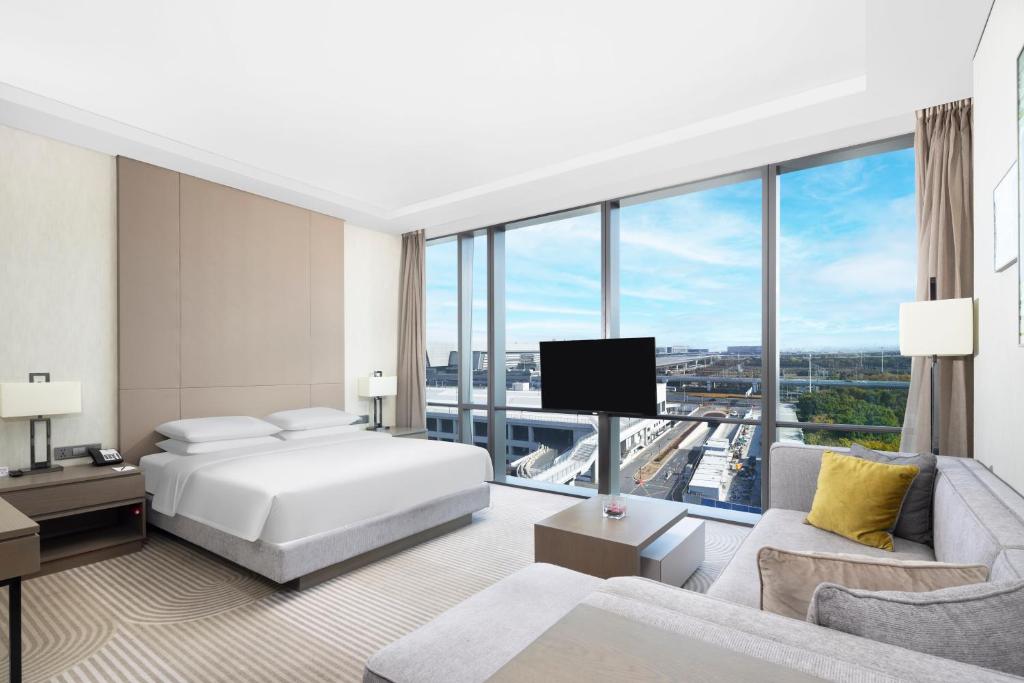 a hotel room with a bed and a large window at Hyatt House Shanghai Hongqiao CBD in Shanghai