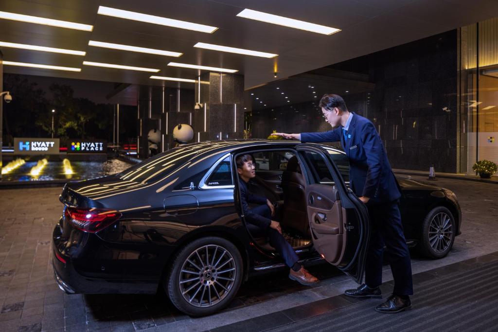 a man in a suit getting into a car at Hyatt House Shanghai Hongqiao CBD in Shanghai