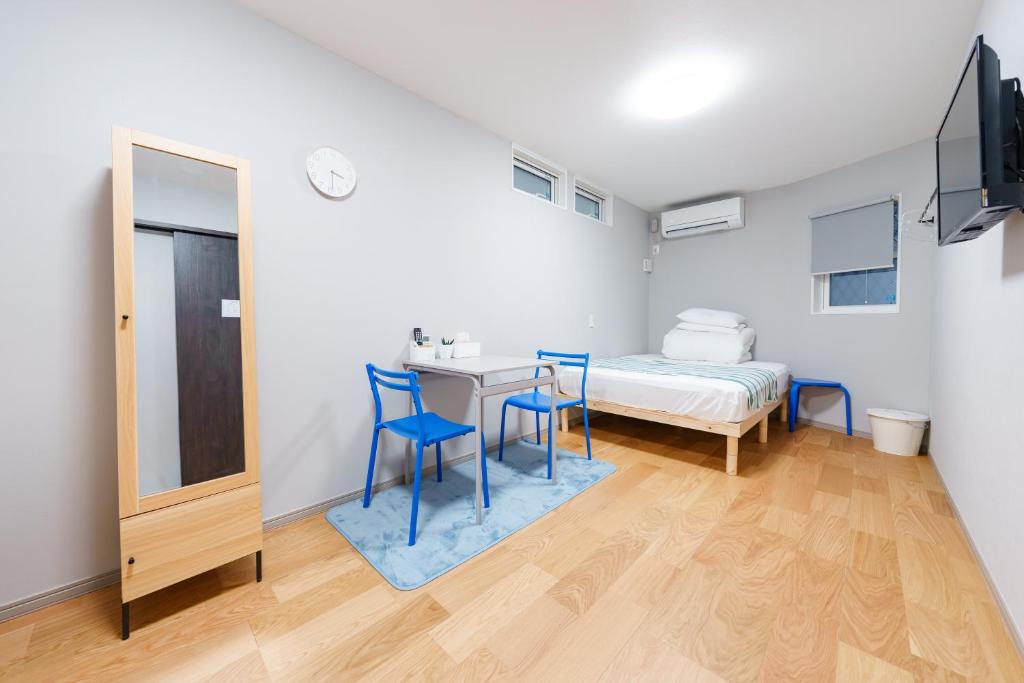 a room with a bed and a table and chairs at Osaka Namba Yeon House in Osaka