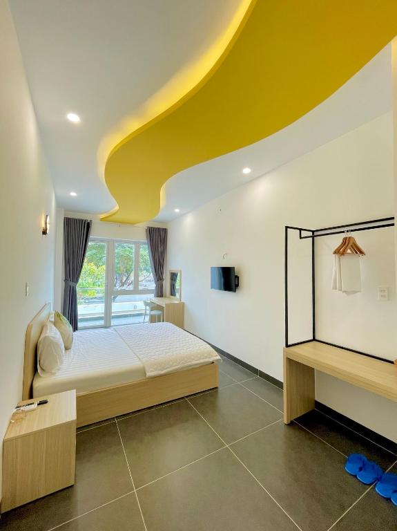 a bedroom with a bed and a yellow ceiling at Baly Hotel Bà Rịa City in Bà Rịa