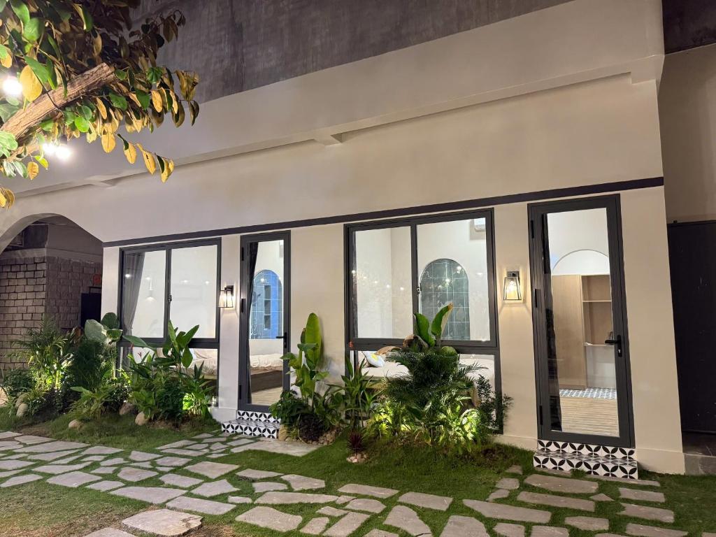a building with windows and plants in a courtyard at K'TY Homestay Phan Thiết in Ấp Bình Hưng