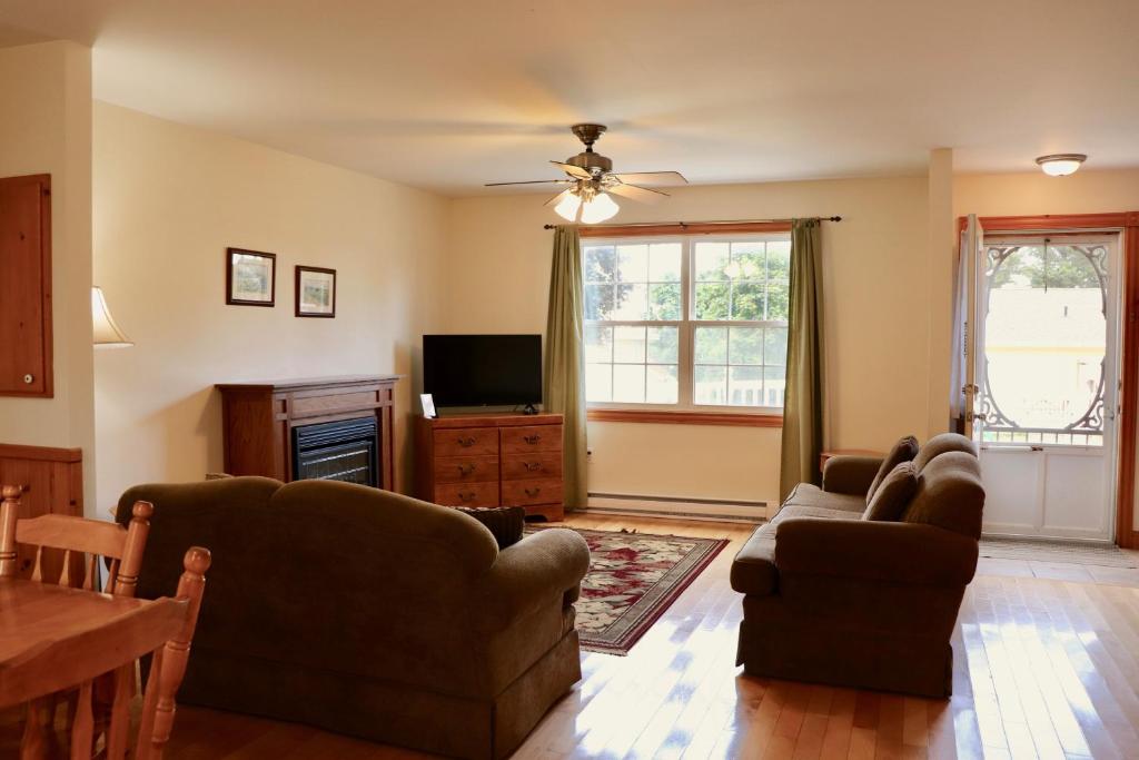 a living room with two couches and a television at Shining Waters - Ingleside Cottages in Cavendish
