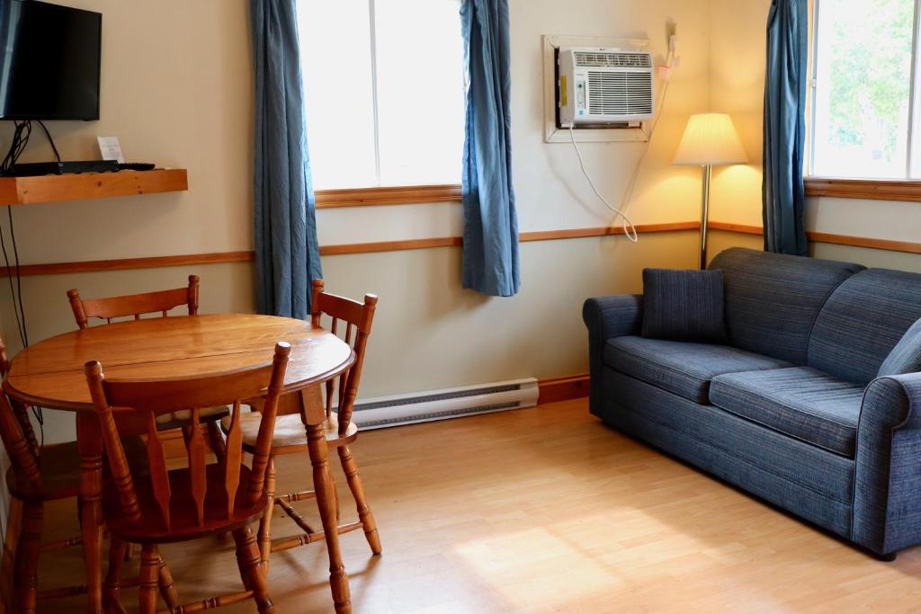 a living room with a couch and a table at Shining Waters - Ingleside Cottages in Cavendish