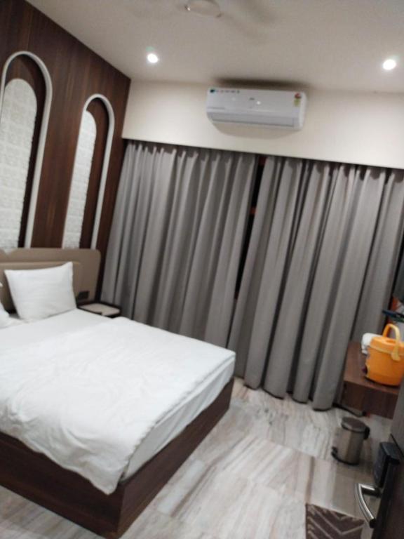 a bedroom with a white bed and a window at Hotel Jai Palace in Ajmer