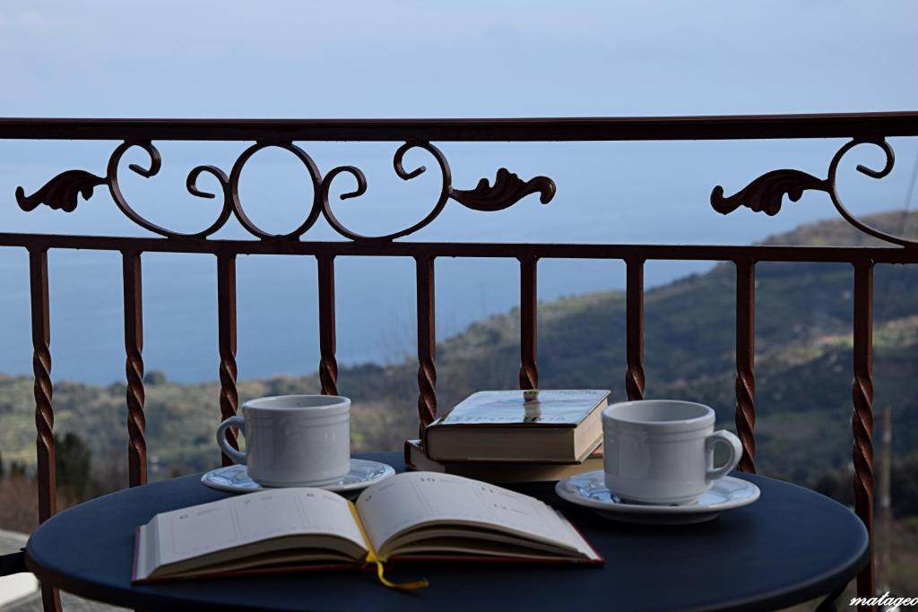 a table with two coffee cups and a book at Victoria's Country Apartments in Zagora