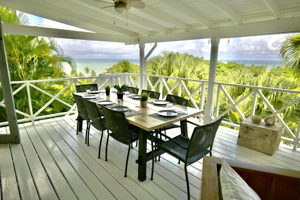 a wooden deck with a table and chairs on it at Villa Valentine LomaBonitaLasTerrenas in Las Terrenas