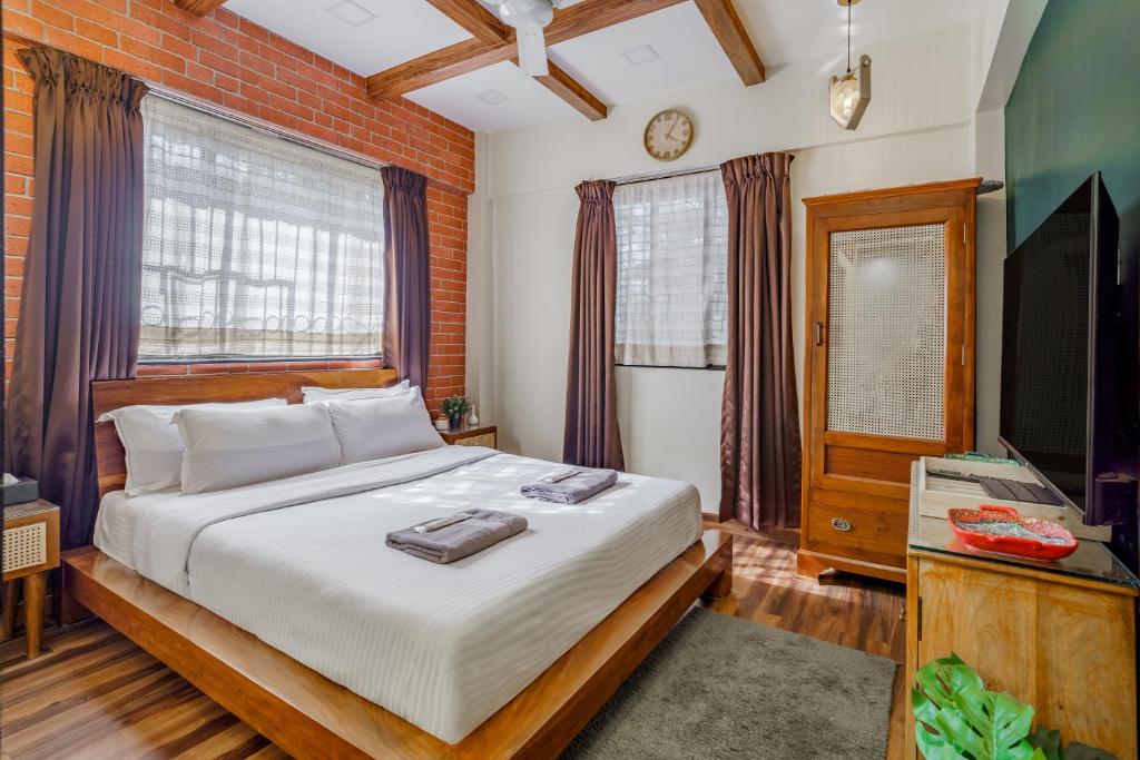 a bedroom with a bed and a flat screen tv at Astra by The Bombay Home Company in Mumbai