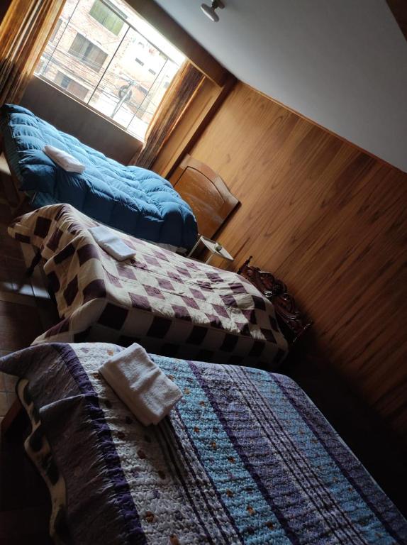 dwa łóżka w pokoju z oknem w obiekcie Habitación familiar en el centro de Puno w mieście Puno