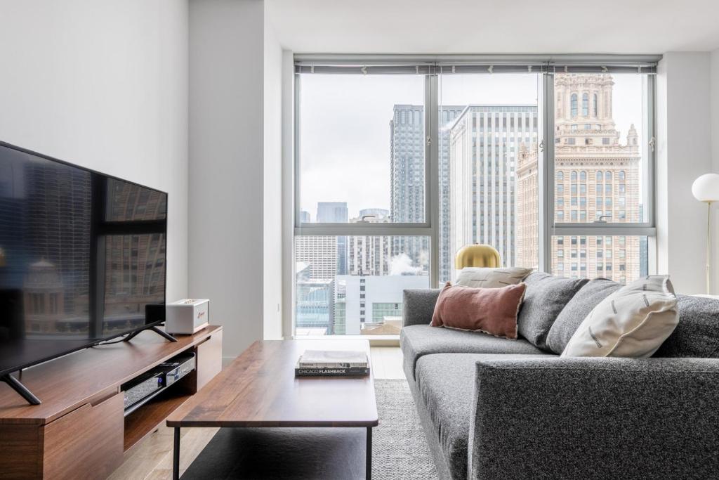 a living room with a couch and a large window at Loop Studio w Gym Pool nr Financial District CHI-239 in Chicago