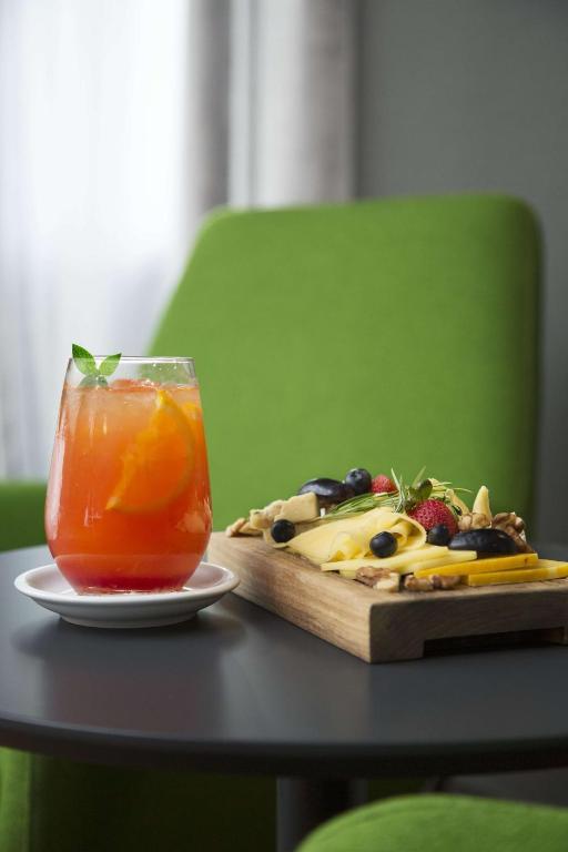 a drink on a table next to a cutting board with fruit at NH Collection Buenos Aires Jousten in Buenos Aires