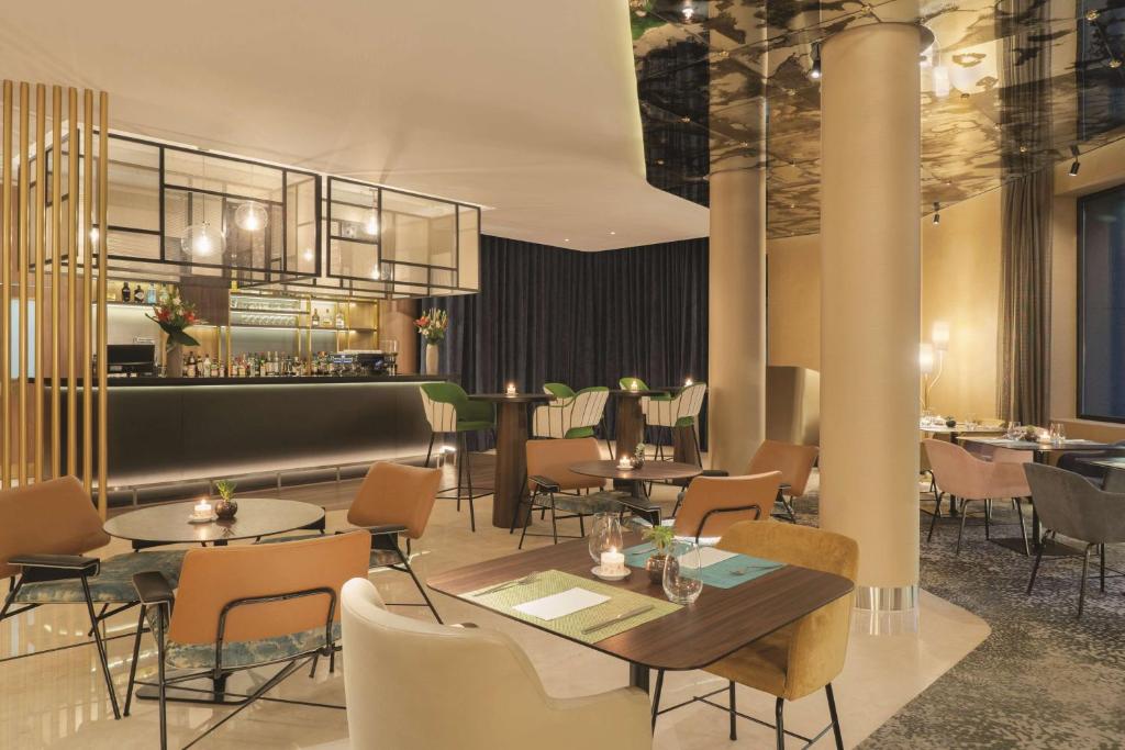 a restaurant with tables and chairs and a bar at NH Collection Buenos Aires Jousten in Buenos Aires