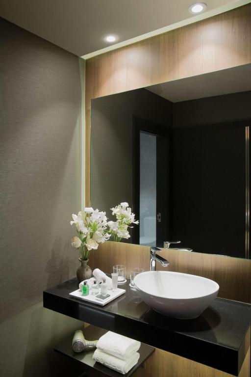 a bathroom with a sink and a large mirror at NH Collection Buenos Aires Jousten in Buenos Aires