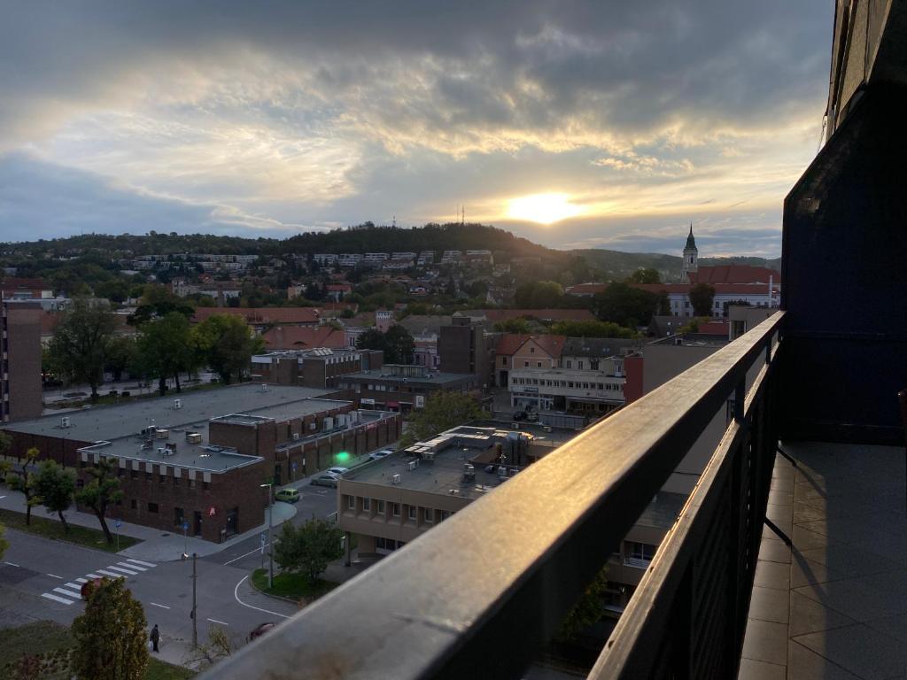 a view of a city at sunset from a balcony at Prométheusz Apartman in Szekszárd