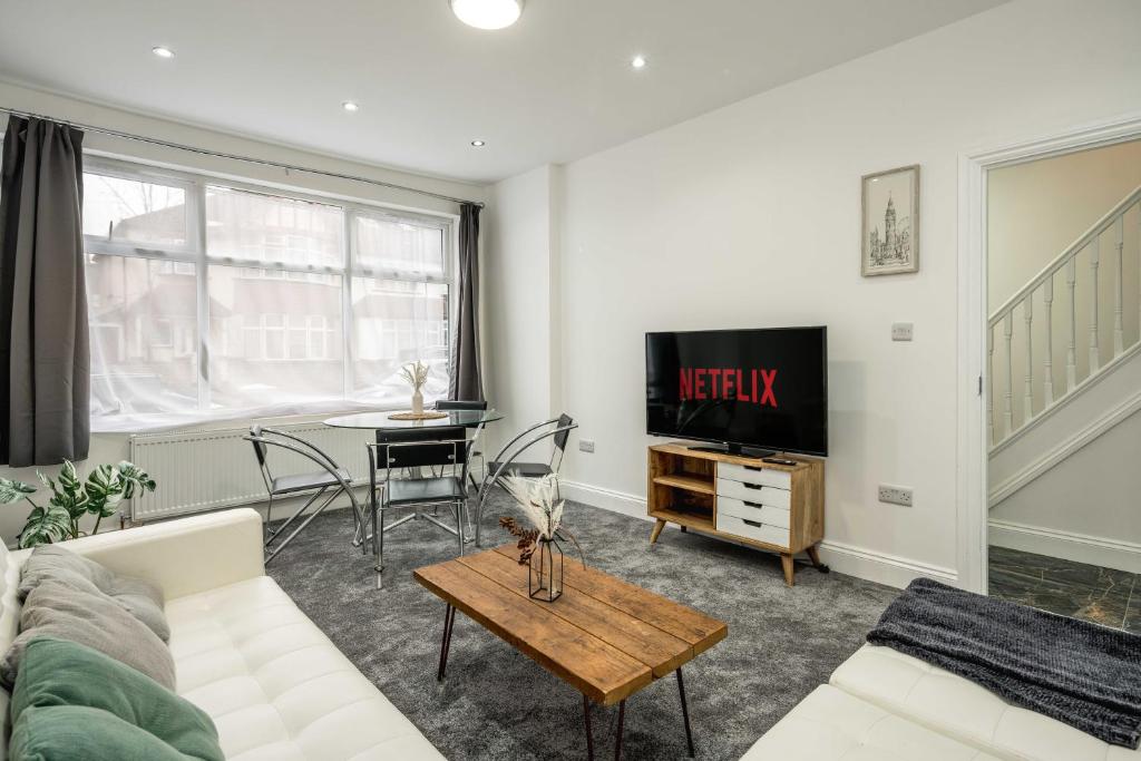 a living room with a couch and a tv and a table at JB Stays Croydon in Thornton Heath