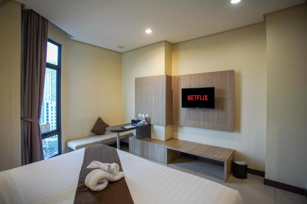 Postel nebo postele na pokoji v ubytování Vasaka Hotel Jakarta Managed by Dafam