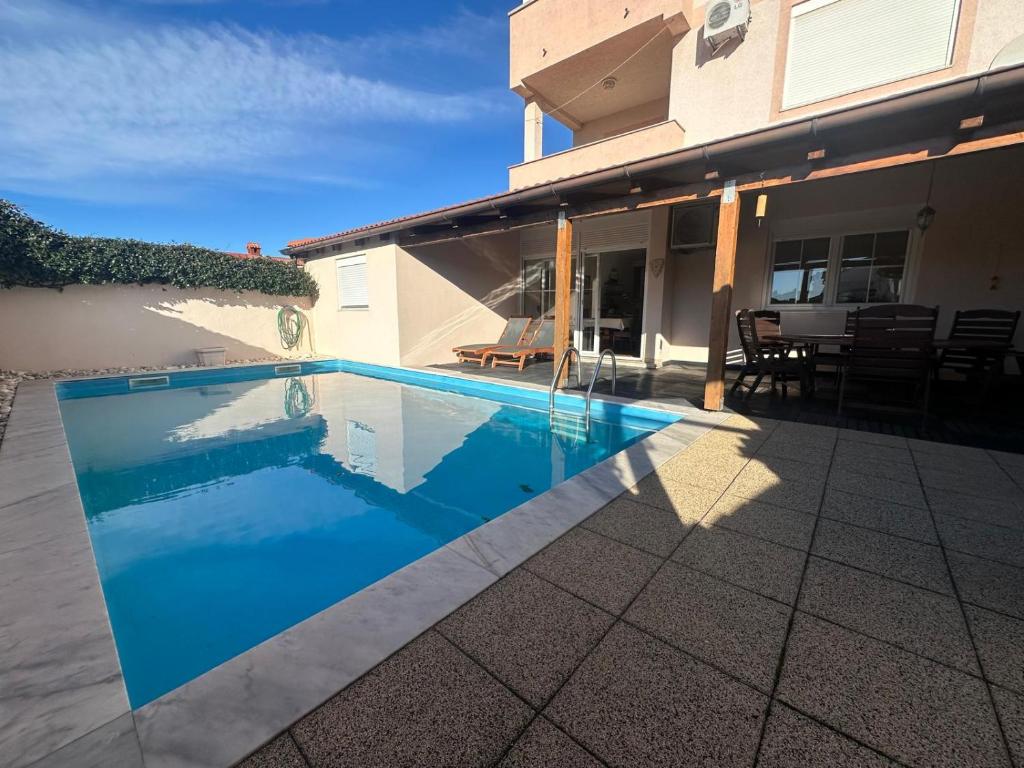 a swimming pool in front of a house at Apartman Surya Medulin in Medulin