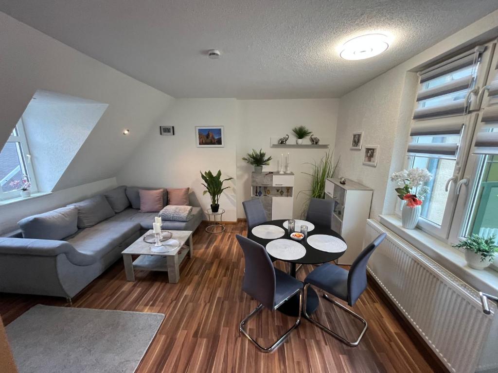 a living room with a couch and a table and chairs at Ferienwohnung Mittweida-City "Schacherhaus" - direkt im Stadtzentrum der Hochschulstadt Mittweida in Mittweida