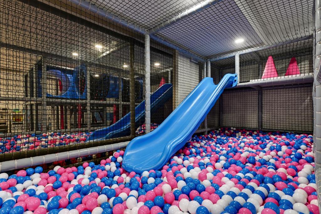 a play room filled with balls and a blue slide at GRANO HOTEL Solmarina in Wiślinka