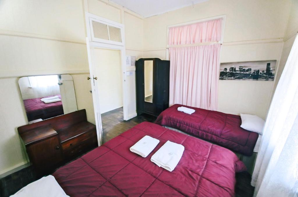 a hotel room with two beds and a mirror at Ryan's Rest Boutique Accommodation in Cairns