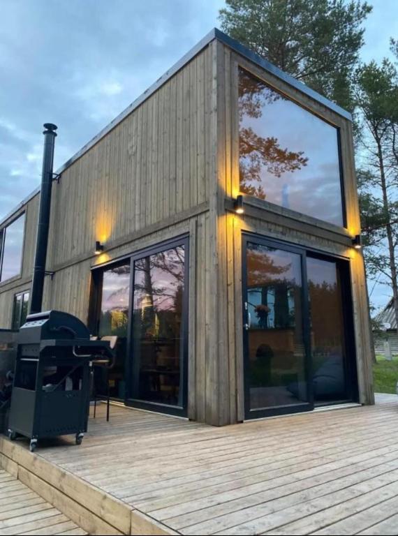 a house with glass doors and a grill on a deck at JES Kalana Beachhouse in Kalana