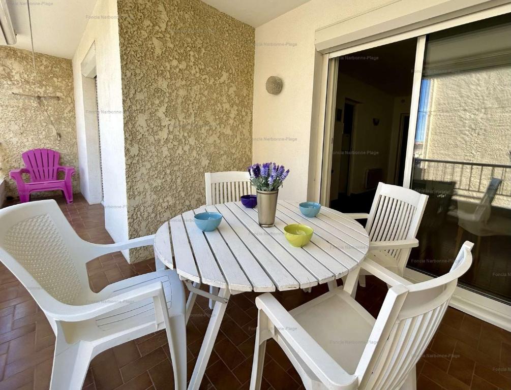 une table et des chaises en bois sur une terrasse dans l'établissement NP530-003 Appartement 3 pièces, Narbonne Plage, à Narbonne-Plage