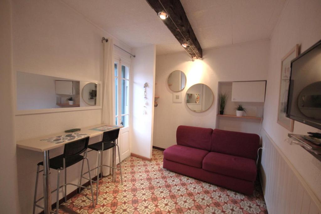 un salon avec un canapé rouge et une table dans l'établissement Treille 2 2ème étage, à Collioure
