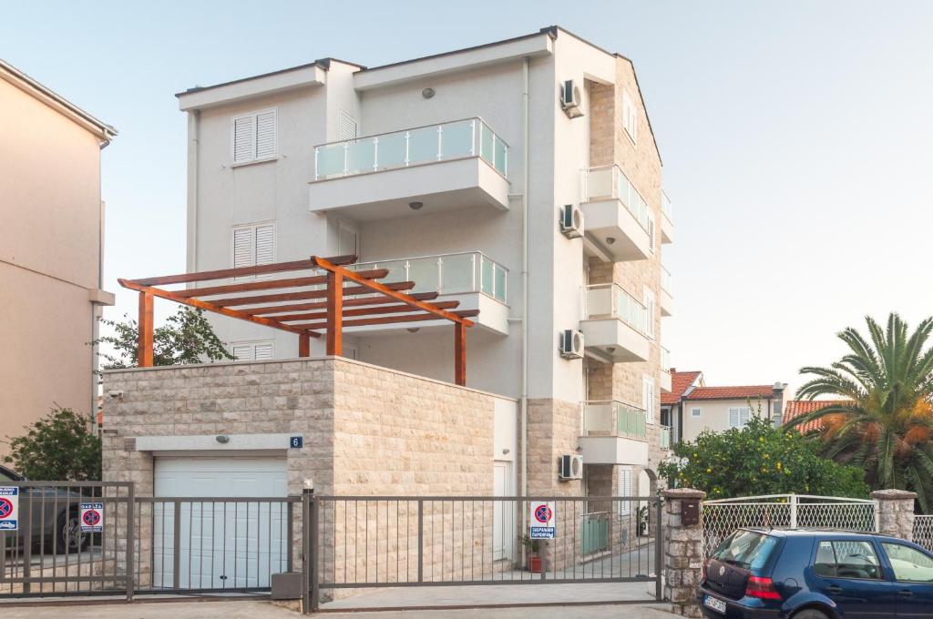 a white building with a balcony on top of it at Apartments LILA AUREA in Petrovac na Moru