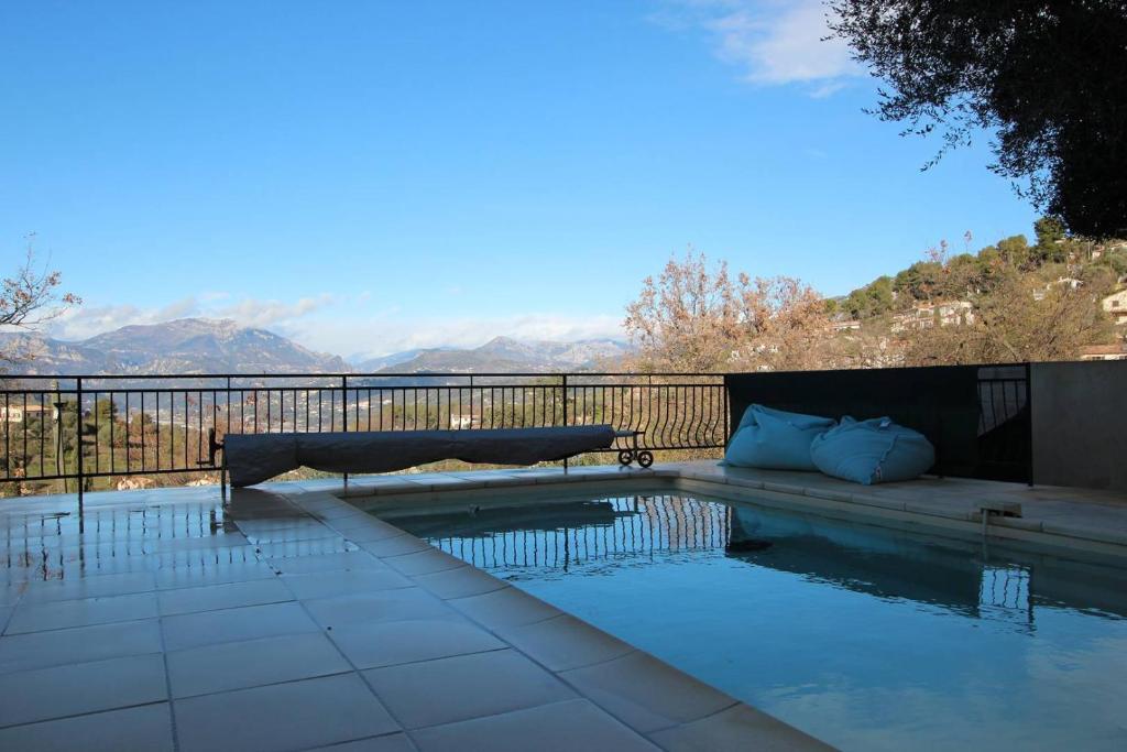 une piscine avec un banc et des montagnes en arrière-plan dans l'établissement Sur les hauteurs de Nice, belle villa idéale en famille ou entre amis, à Colomars