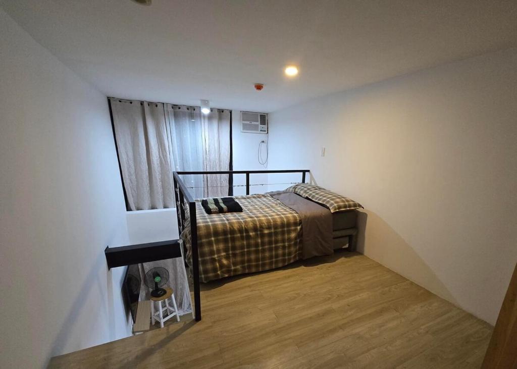 マンダウエ・シティにあるCentro City Loftのベッドと窓のある小さな寝室