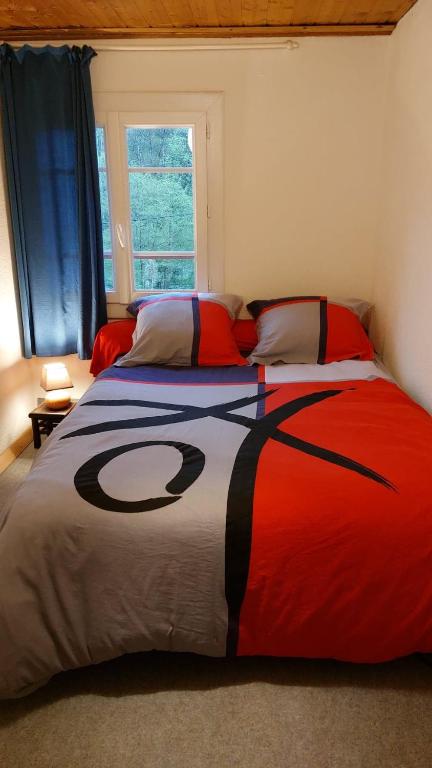 - une chambre avec un grand lit et une couverture dans l'établissement la maison du bonheur chez Yann HUMBLET, à Moulis