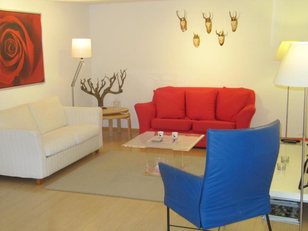 ein Wohnzimmer mit einem roten Sofa und einem Tisch in der Unterkunft Landhaus zur Linde in Winterberg
