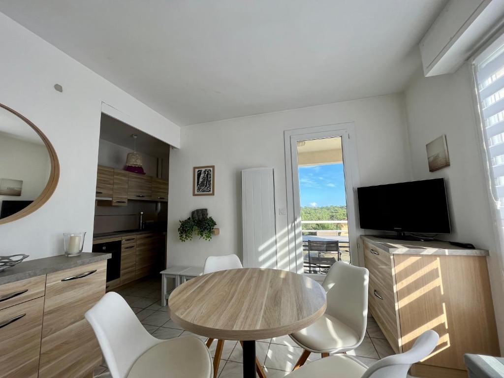 une cuisine avec une table et des chaises et une télévision dans l'établissement Le Duna, à Soorts-Hossegor