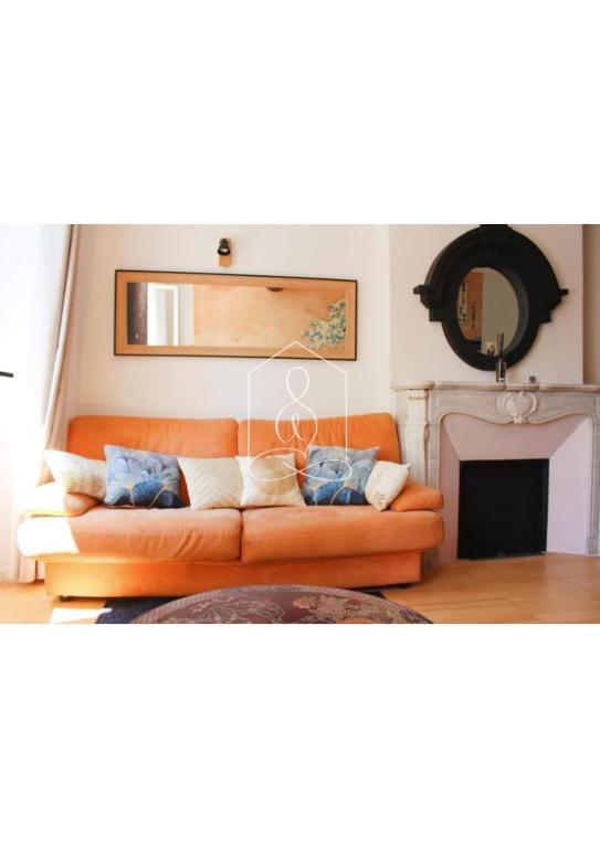 - un canapé orange dans le salon avec cheminée dans l'établissement La Vague, au coeur du village de Montauroux, à Montauroux