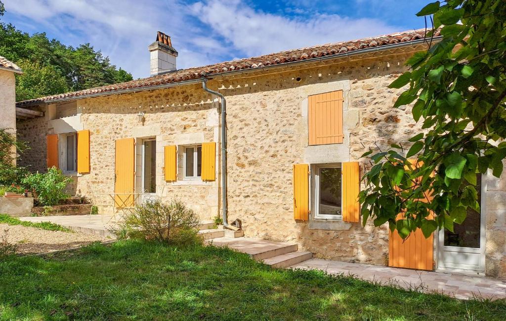 une vieille maison en pierre avec des volets jaunes dans l'établissement 2 Bedroom Gorgeous Home In Grassac, à Grassac