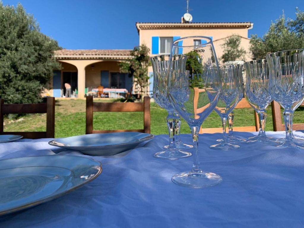 une table avec des verres à vin sur un chiffon de table bleu dans l'établissement Sunset Ridge house, à Pierrevert