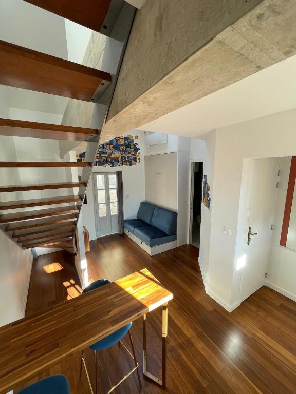 un salon avec un escalier et un canapé bleu dans l'établissement Little Lewis by Home&Art, à Montpellier